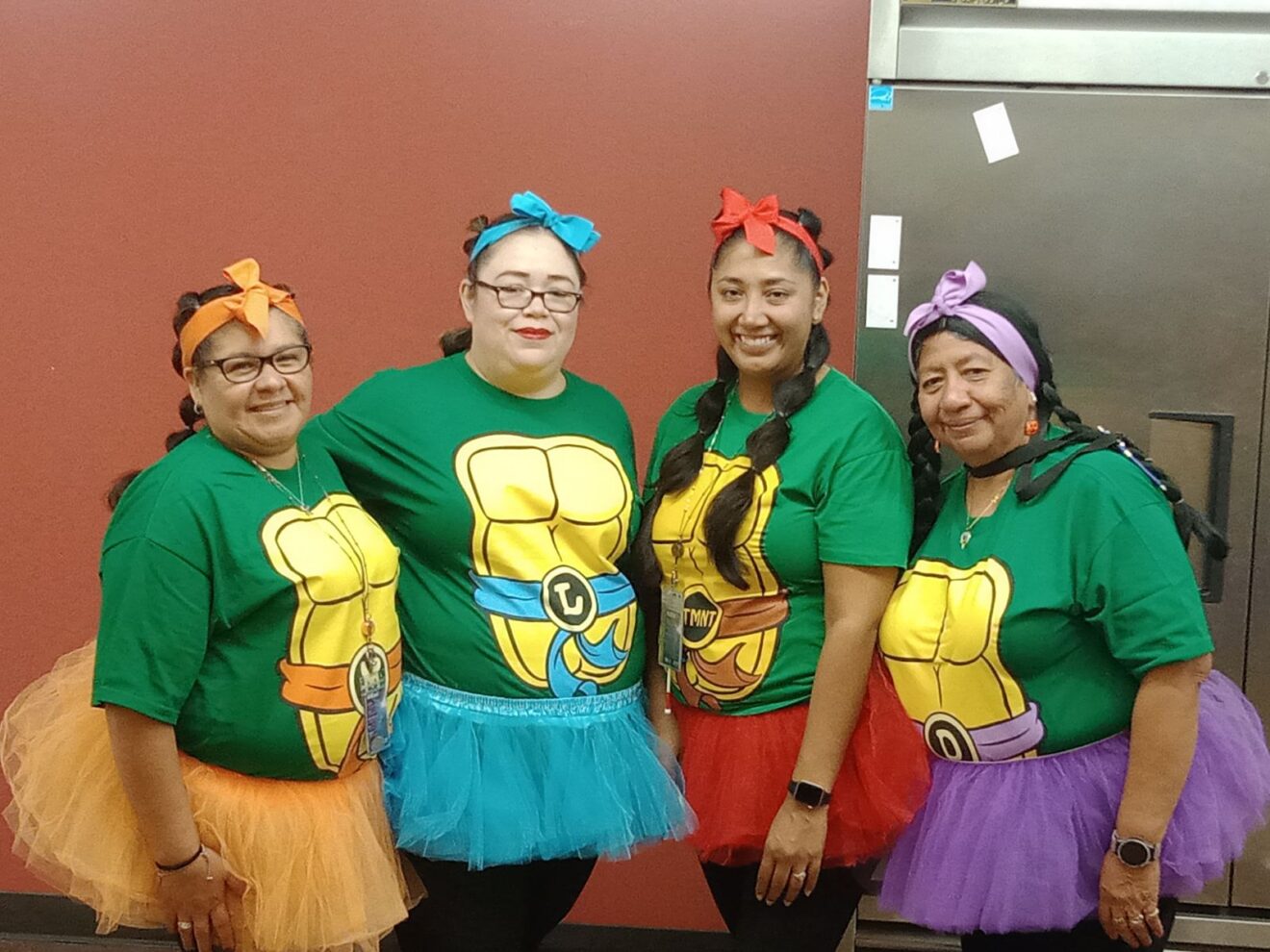 Four women pose together dressed as Ninja Turtles